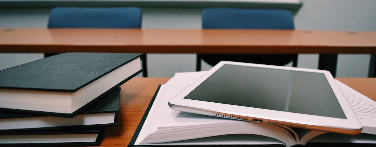 Bücher und ein Laptop auf einem Holztisch