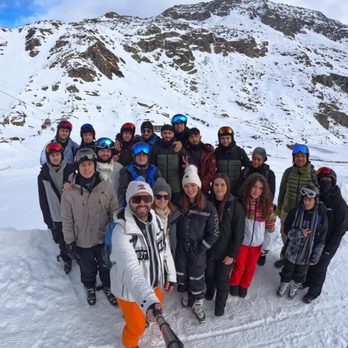 Schülergruppe in Winterkleidung auf einem verschneiten Berghang