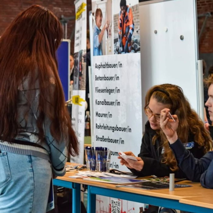 Beratungsgespräch an einem Messestand zum Thema Ausbildung