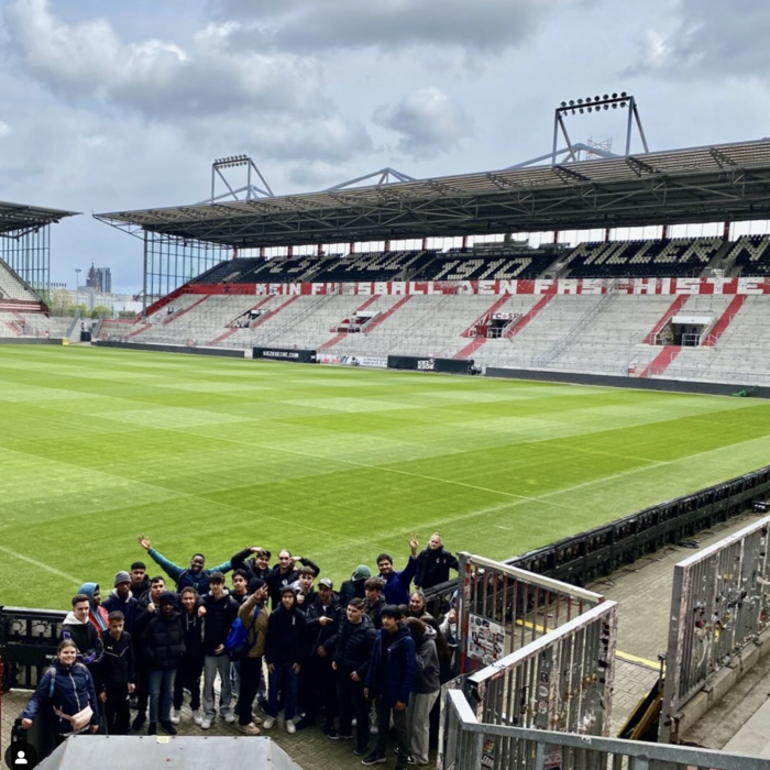Große Schülergruppe auf der Tribüne eines Fußballstadions