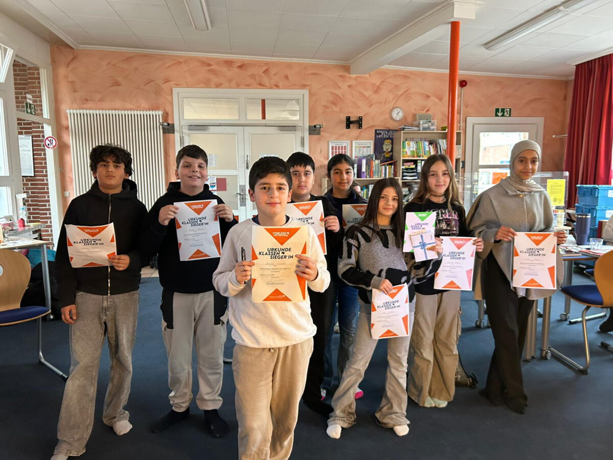 Schülerinnen und Schüler zeigen ihre Urkunden vom Lesewettbewerb