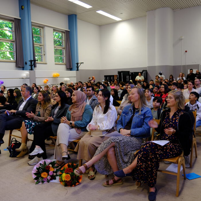 Gut gefüllte Aula mit Gästen bei der Einschulungsfeier