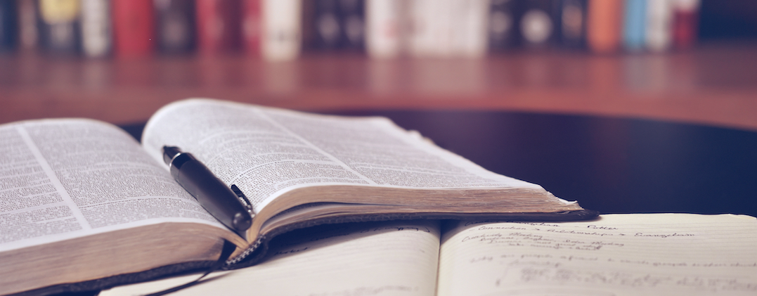 Zwei aufgeschlagene Bücher liegen auf einem Tisch