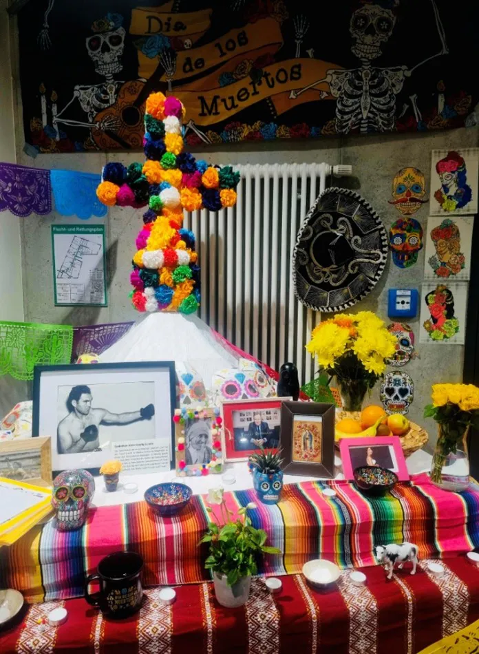 Bunt geschmückter Altar zum Día de los Muertos mit Blumen und Bildern