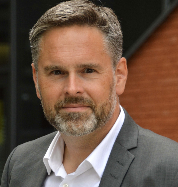 Schulleiter Philipp Scholz in weißem Hemd und grauem Jackett